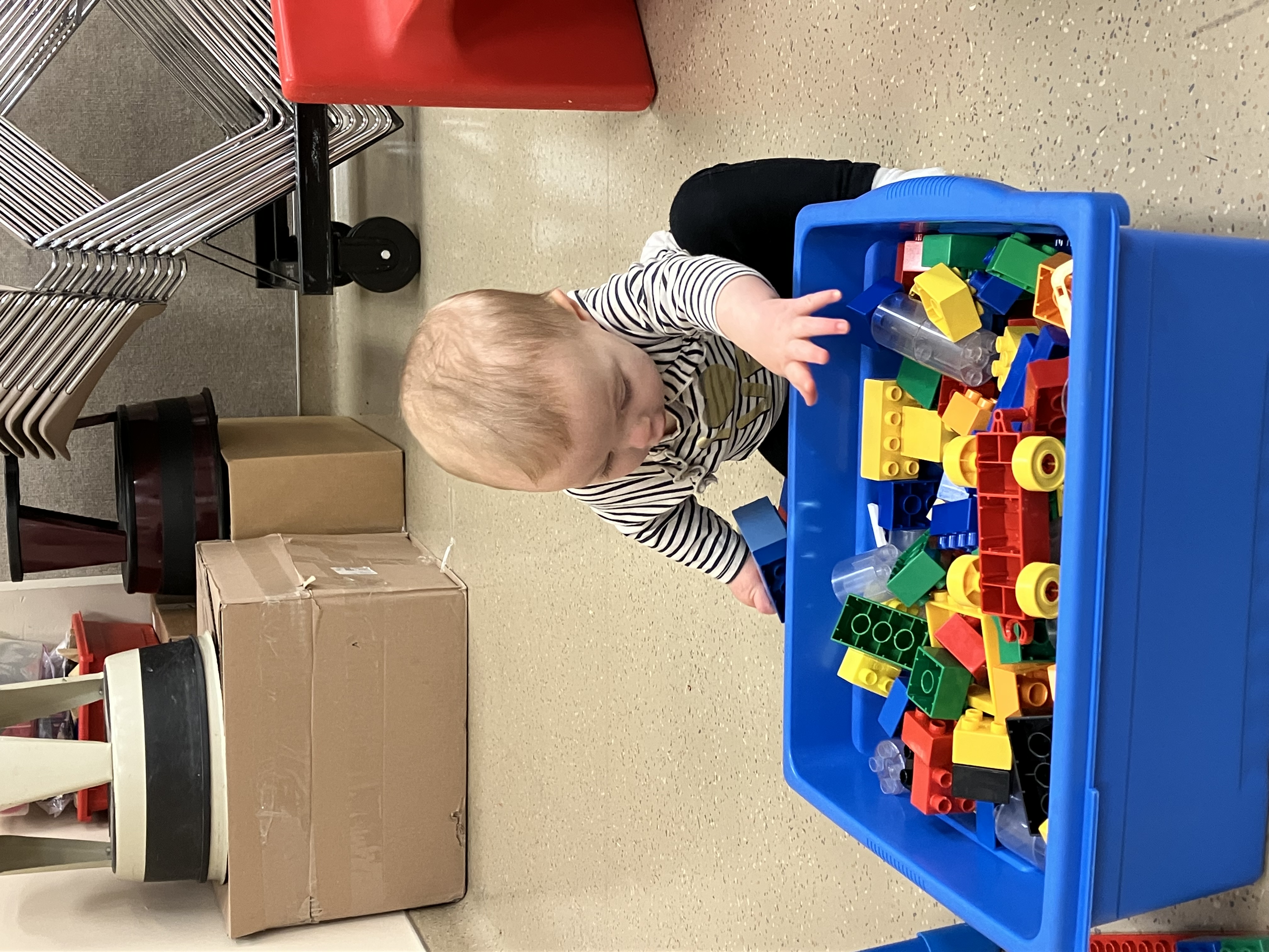 a baby reaches for duplo blocks